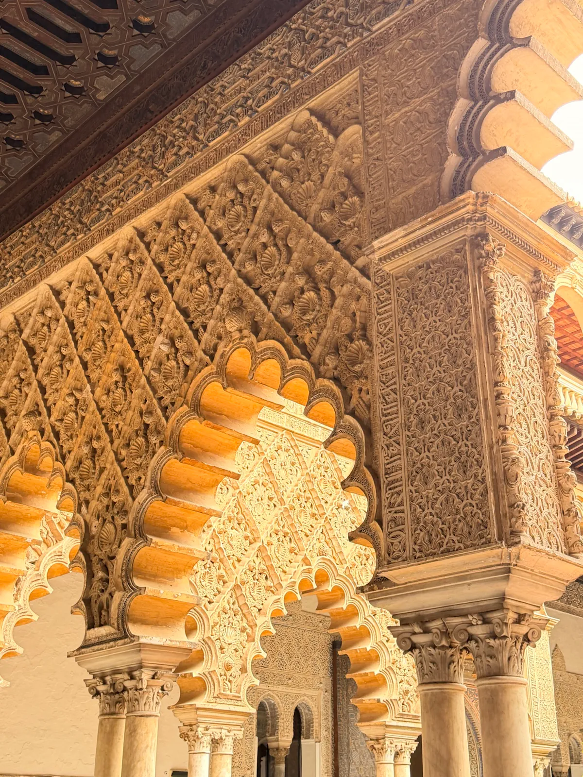Mudéjar arches and carved plasterwork inside the Royal Alcázar of Seville