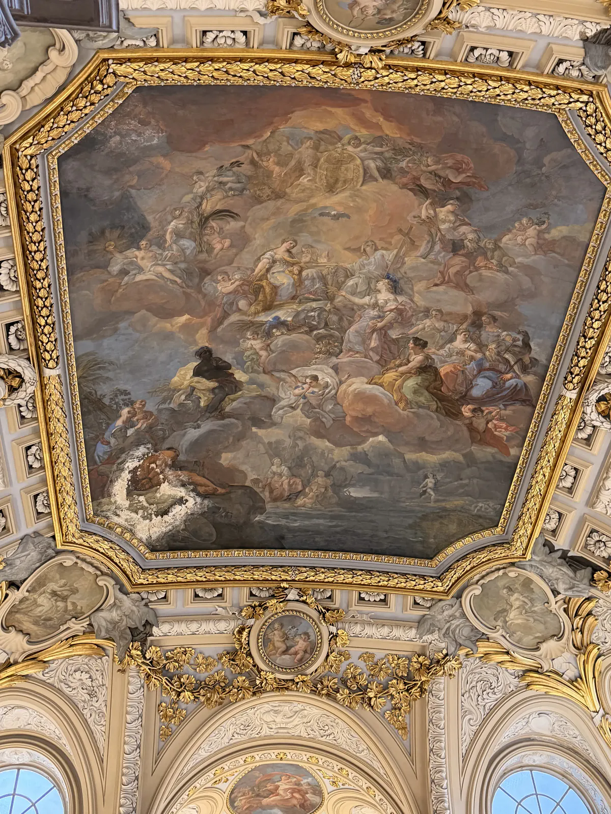 Large painted ceiling fresco framed in gold inside the Royal Palace of Madrid