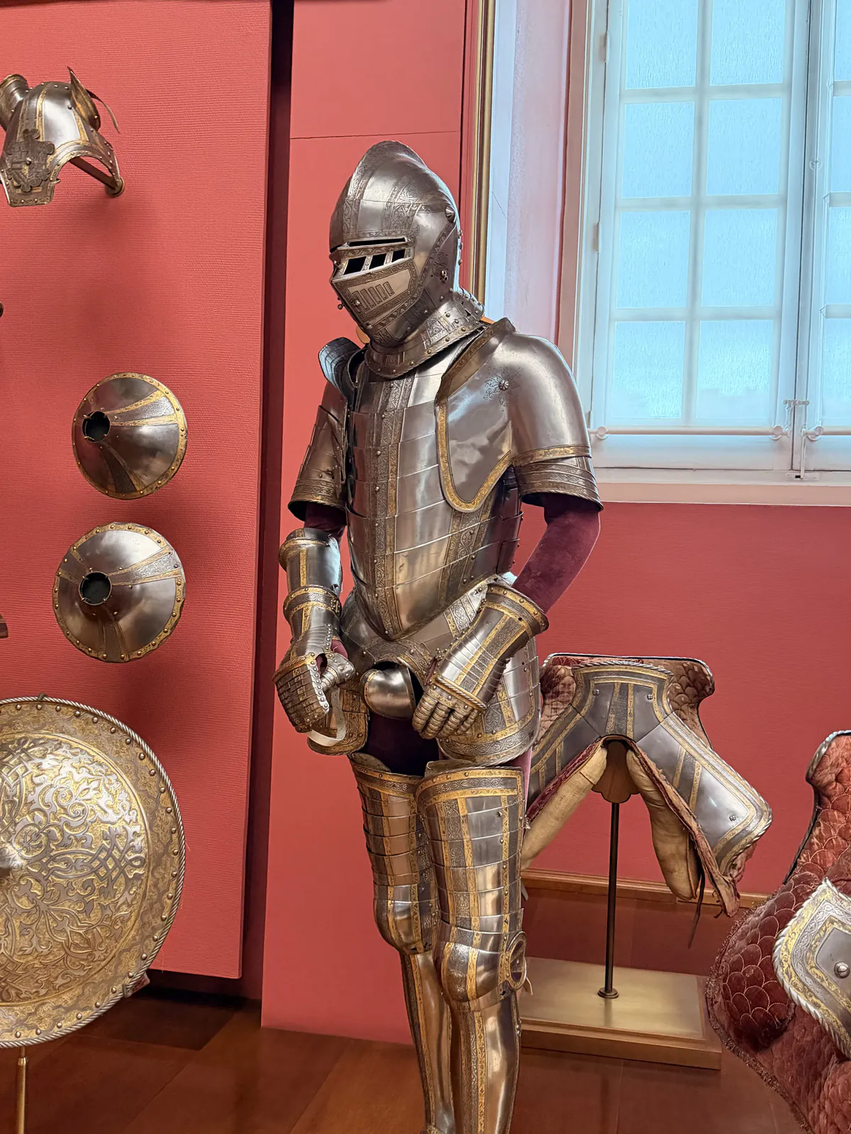 Detailed suit of armor with gilded metalwork inside the Royal Armoury of Madrid