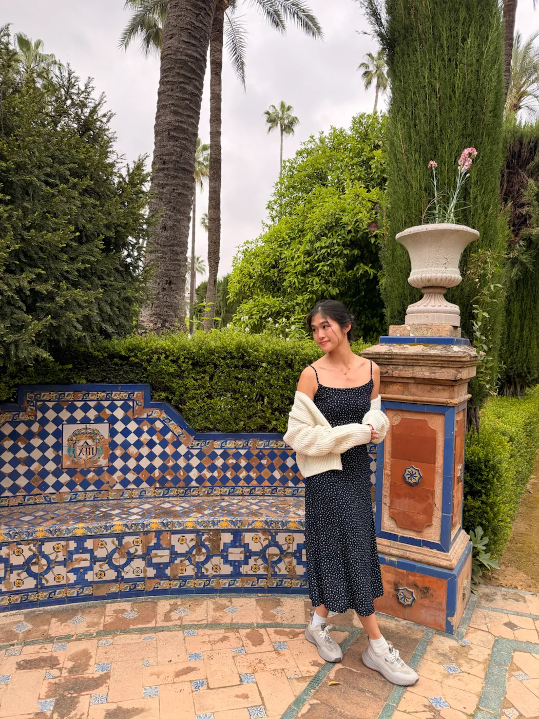 Tiled bench beneath palm trees in the gardens of the Royal Alcázar of Seville
