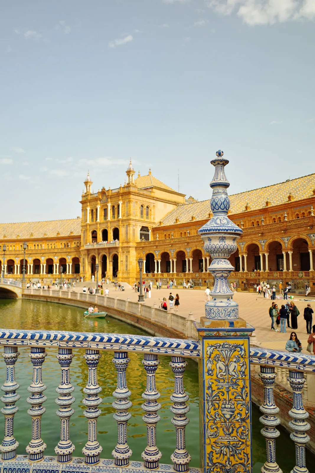 Blue-and-white ceramic railing on a bridge looking along the canal at Plaza de España in Seville