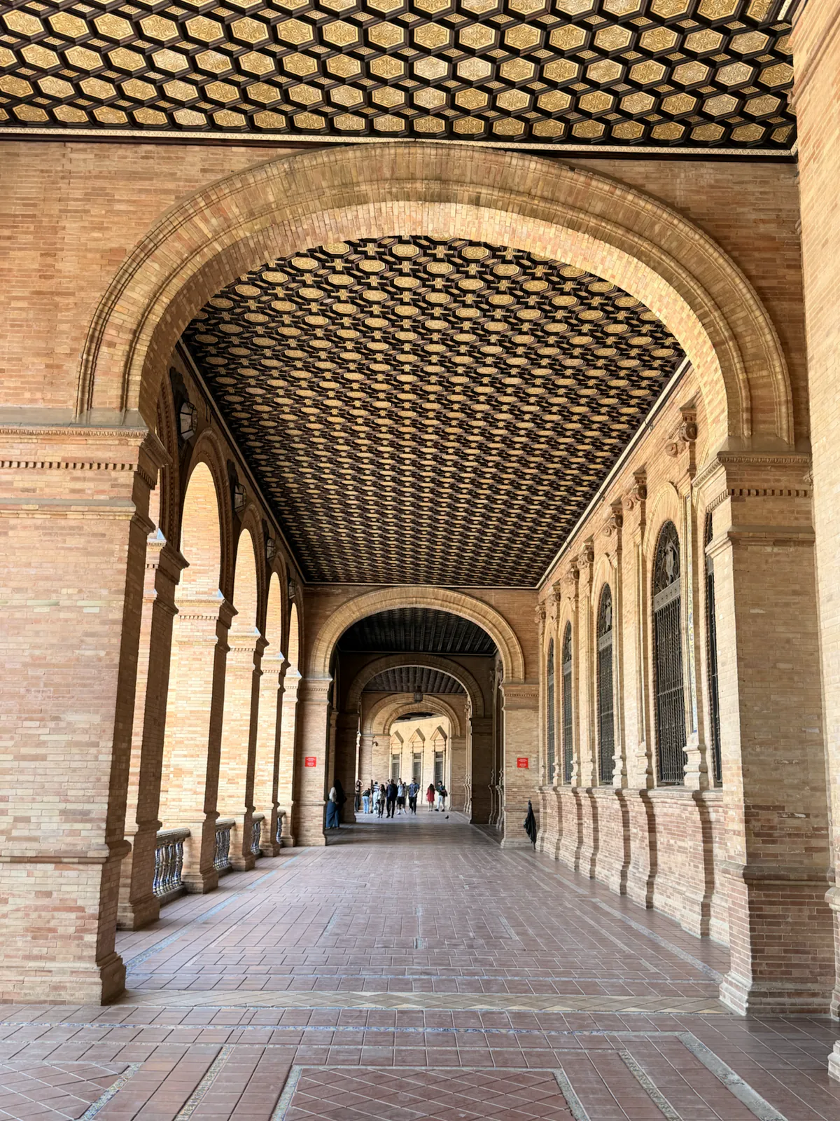 Covered arcade with a painted tiled ceiling at Plaza de España in Seville