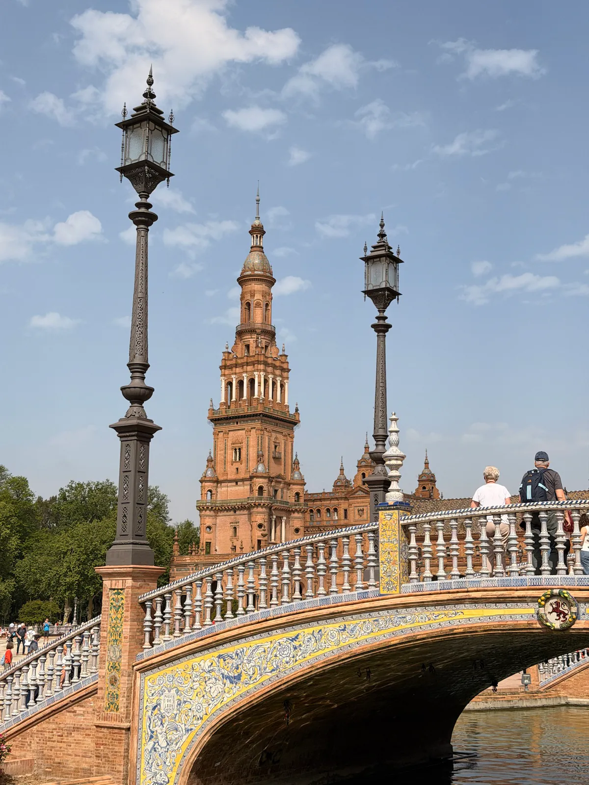 A tiled bridge and tower at Plaza de España in Seville