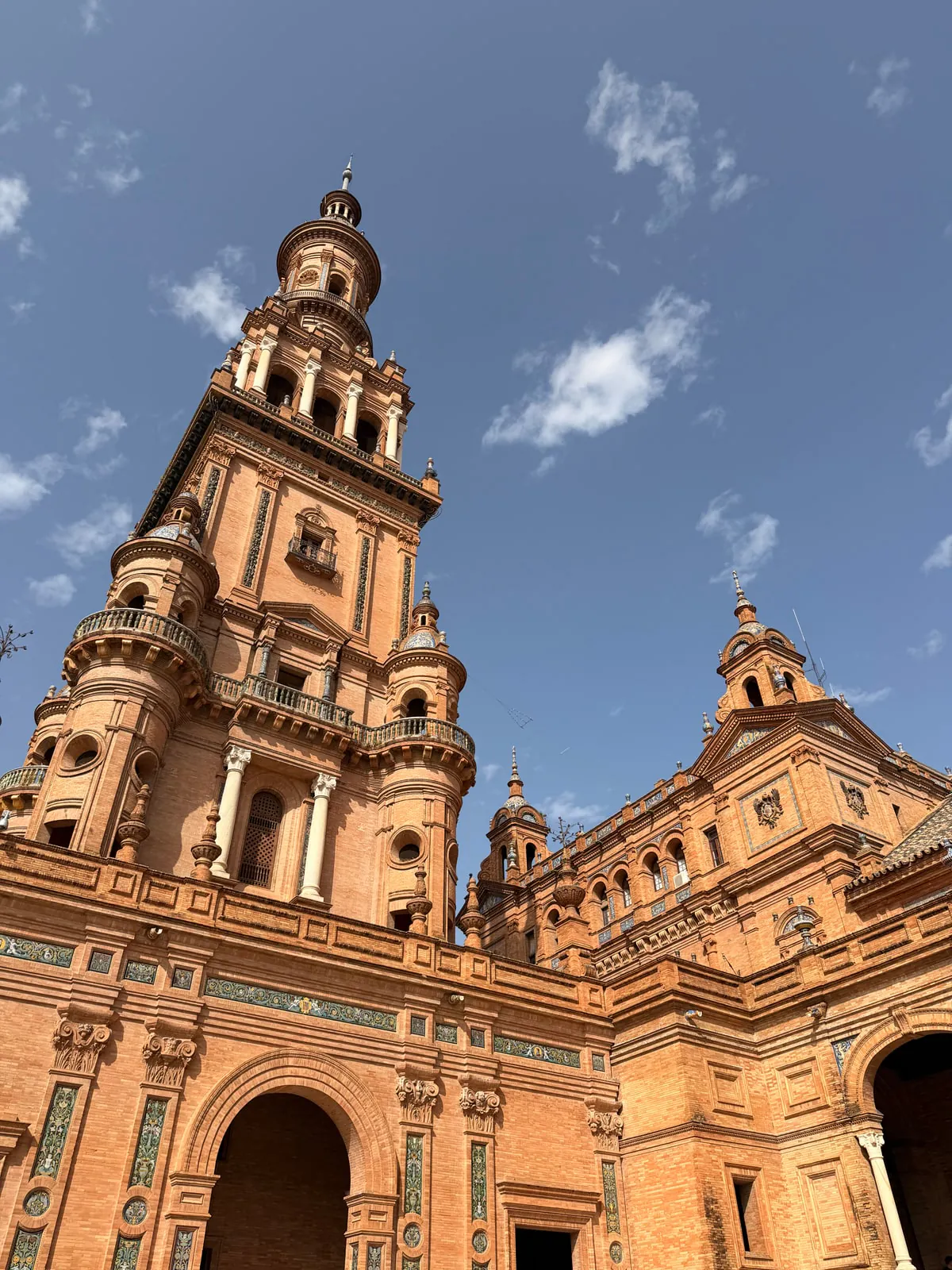 Looking up at one of the brick and ceramic towers at Plaza de España in Seville