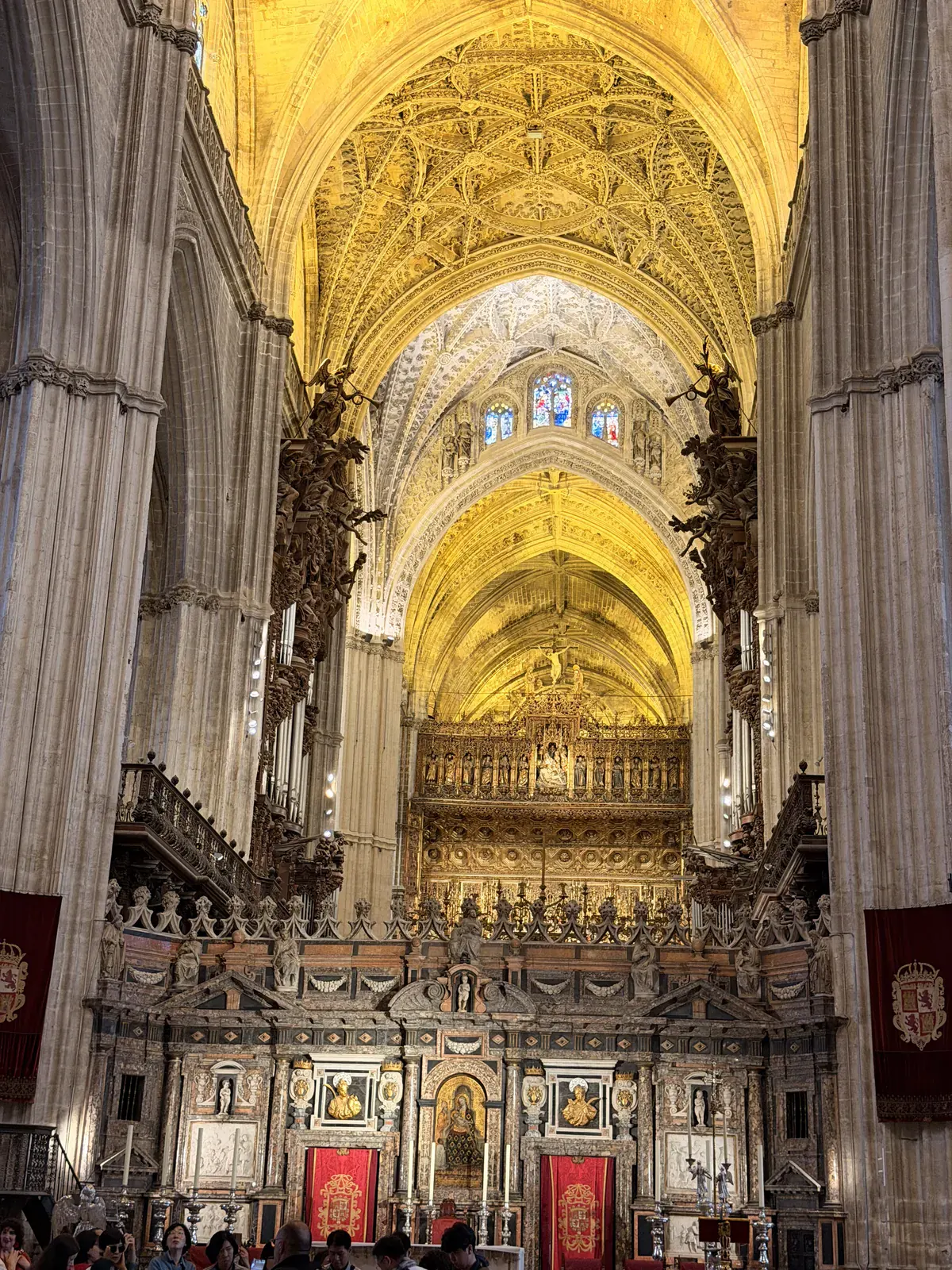 The illuminated vaulted nave and ornate choir inside Seville Cathedral.