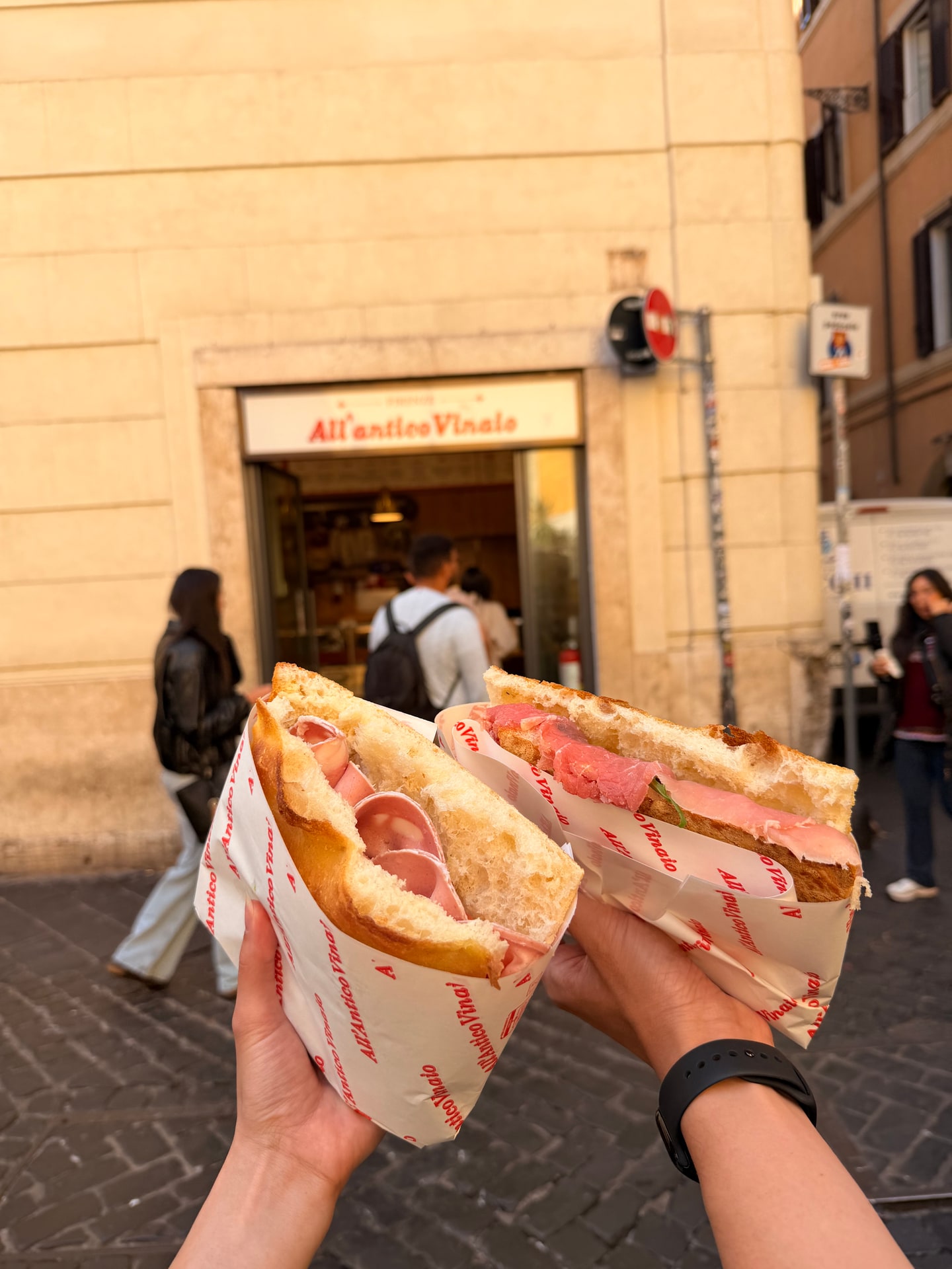 Two filled panini held outside All'Antico Vinaio in Rome