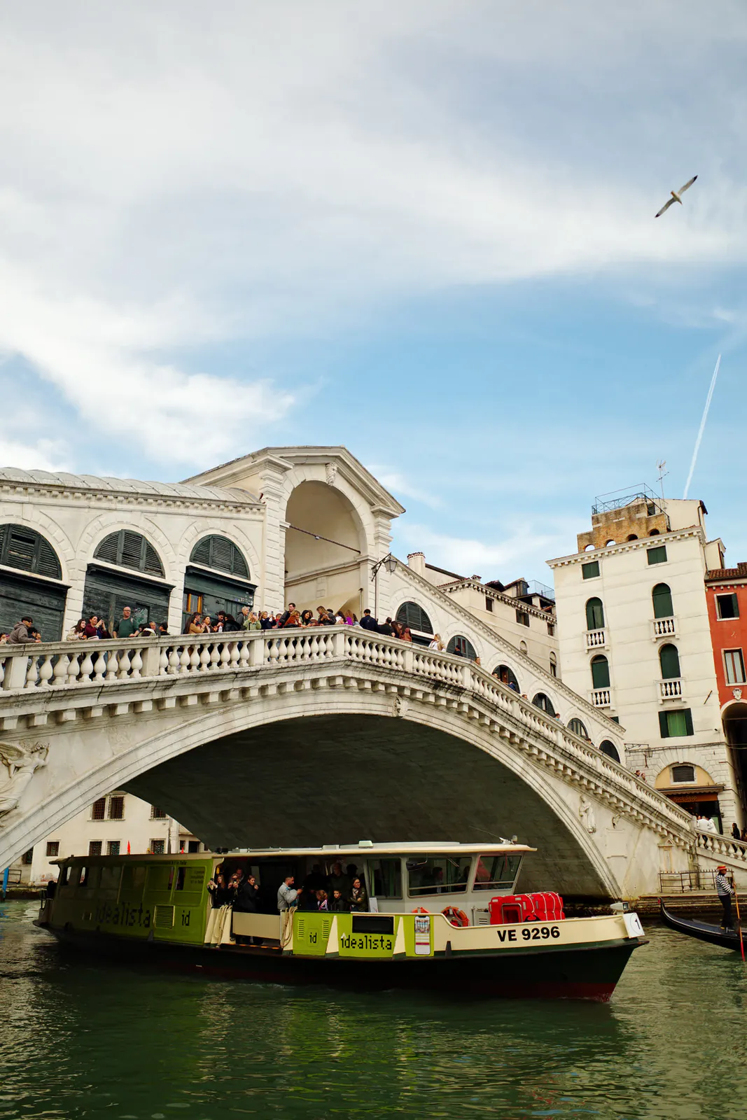 Stone arches of Rialto Bridge viewed from beside the Grand Canal in Venice